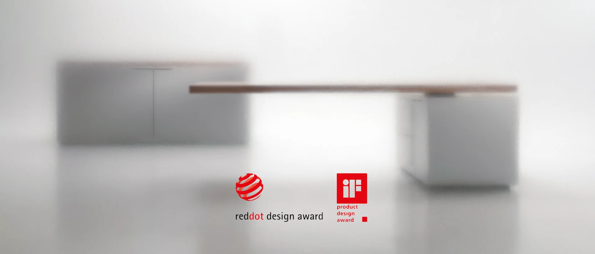 ACUTO, unscharf: Tischplatte und Container, dazu die Zeichen Red Dot Design Award und iF Product Design Award