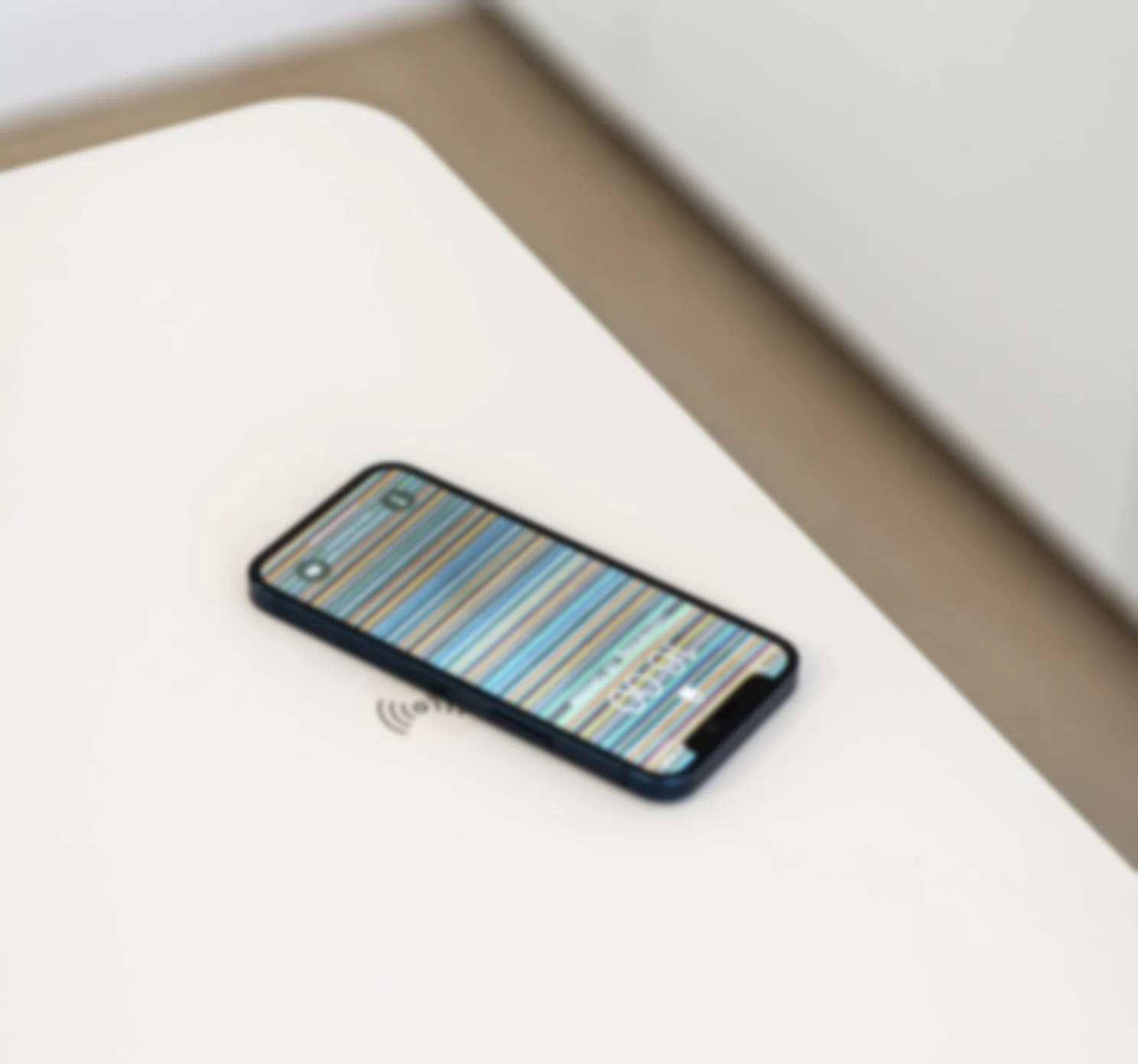 Tischplatte, unscharf: ein Telefon liegt auf dem Ladefeld